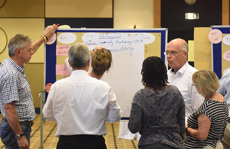 A group of people discussing in front of a flip chart.